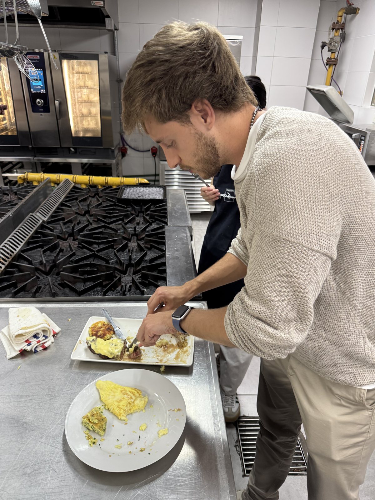 Facundo plating a dish on the line in a professional kitchen