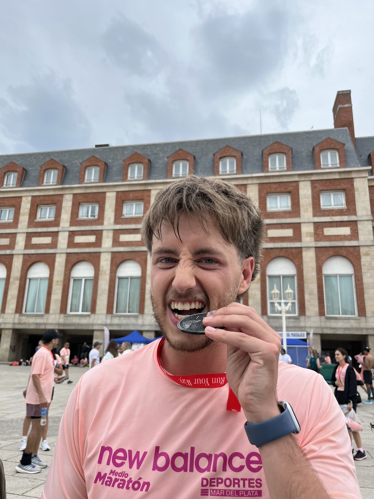 Facundo biting his finisher medal after a half marathon