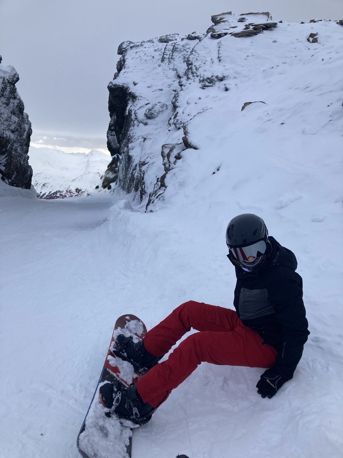 Facundo strapped into a snowboard on a mountain slope